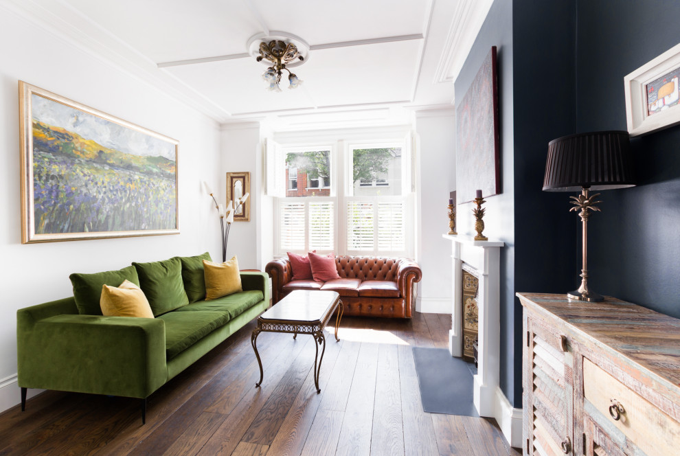 Idéer för ett klassiskt vardagsrum, med blå väggar, mörkt trägolv, en standard öppen spis och brunt golv