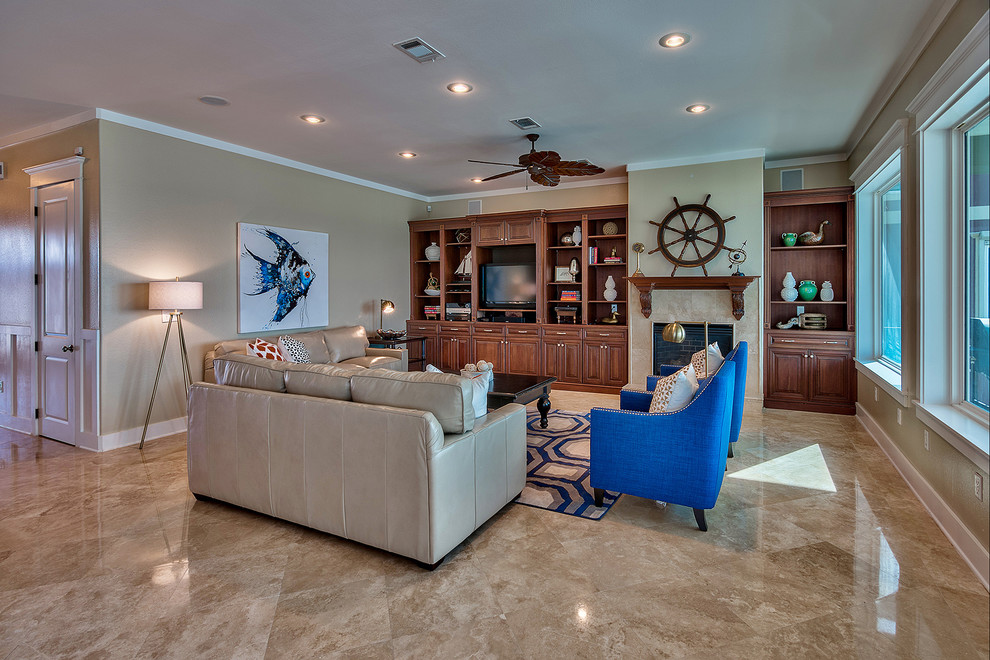 This is an example of a large nautical open plan living room in Miami with beige walls, porcelain flooring, a standard fireplace, a tiled fireplace surround and a built-in media unit.