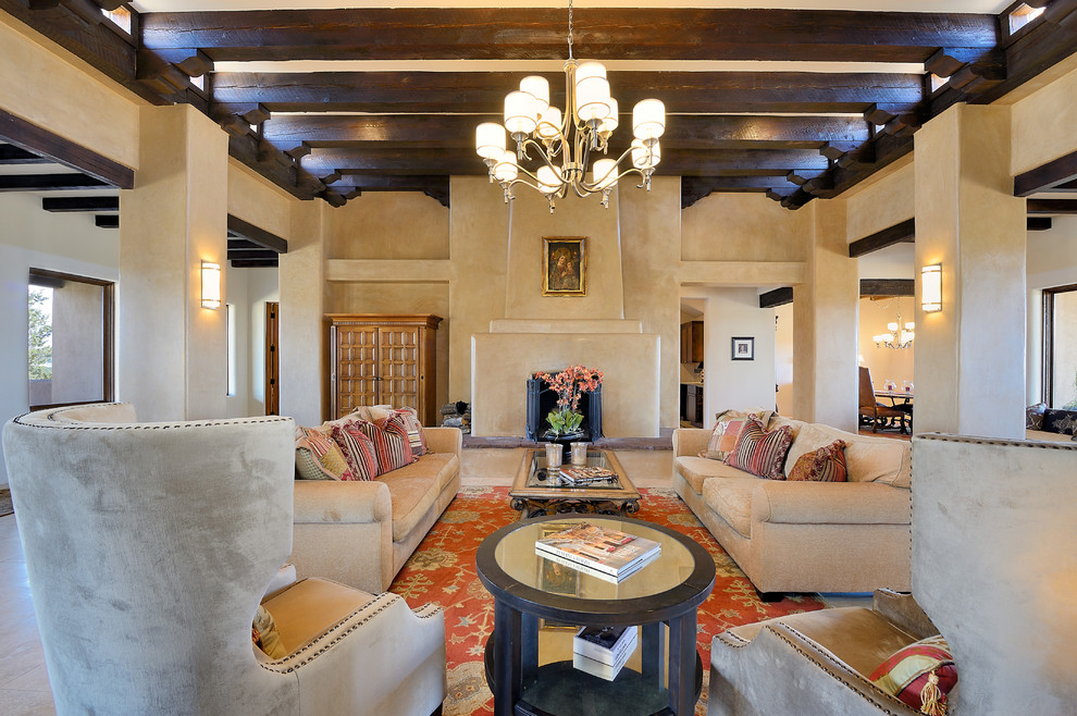 Fernseherloses, Offenes Mediterranes Wohnzimmer mit beiger Wandfarbe, Kamin, verputzter Kaminumrandung und beigem Boden in Albuquerque