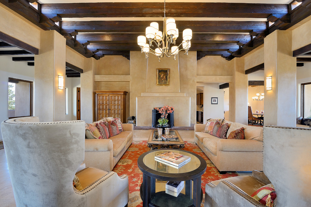 Living room - southwestern open concept beige floor living room idea in Albuquerque with beige walls, a standard fireplace, a plaster fireplace and no tv
