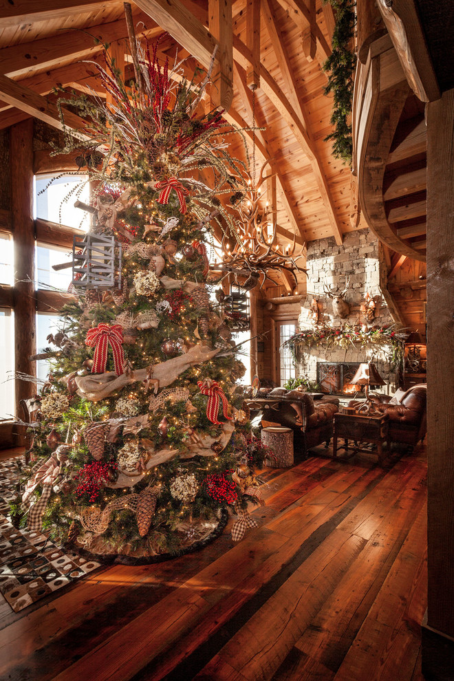 Rustic formal open plan living room in Atlanta with brown walls, a standard fireplace, a stone fireplace surround, no tv and brown floors.