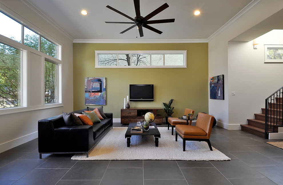 На фото: гостиная комната в современном стиле с желтыми стенами, телевизором на стене, акцентной стеной и ковром на полу с