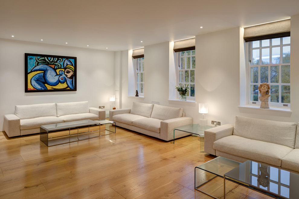 Modelo de salón para visitas abierto vintage grande con paredes blancas y suelo de madera clara