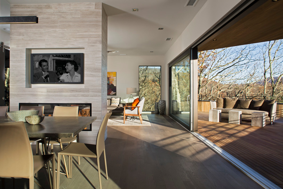 Großes, Abgetrenntes Modernes Wohnzimmer mit grauer Wandfarbe, hellem Holzboden, Kaminumrandung aus Stein und Multimediawand in Sonstige