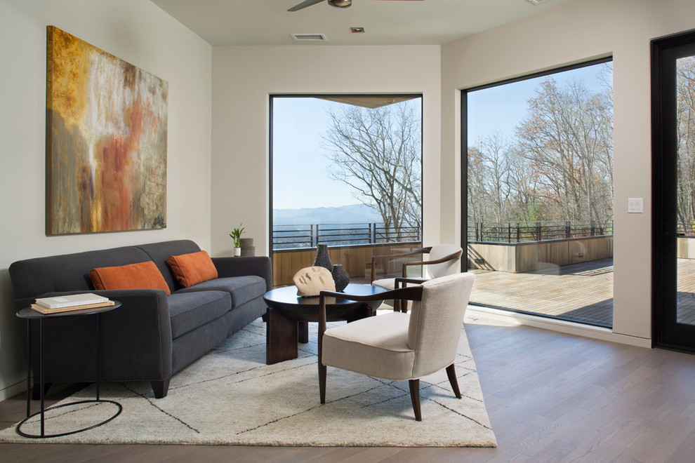 Großes, Fernseherloses Modernes Wohnzimmer ohne Kamin mit braunem Holzboden und weißer Wandfarbe in Sonstige