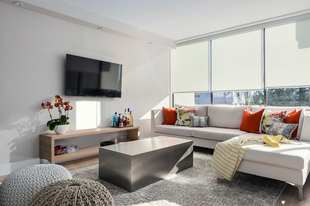 На фото: парадная, открытая гостиная комната среднего размера в современном стиле с белыми стенами, светлым паркетным полом и телевизором на стене без камина