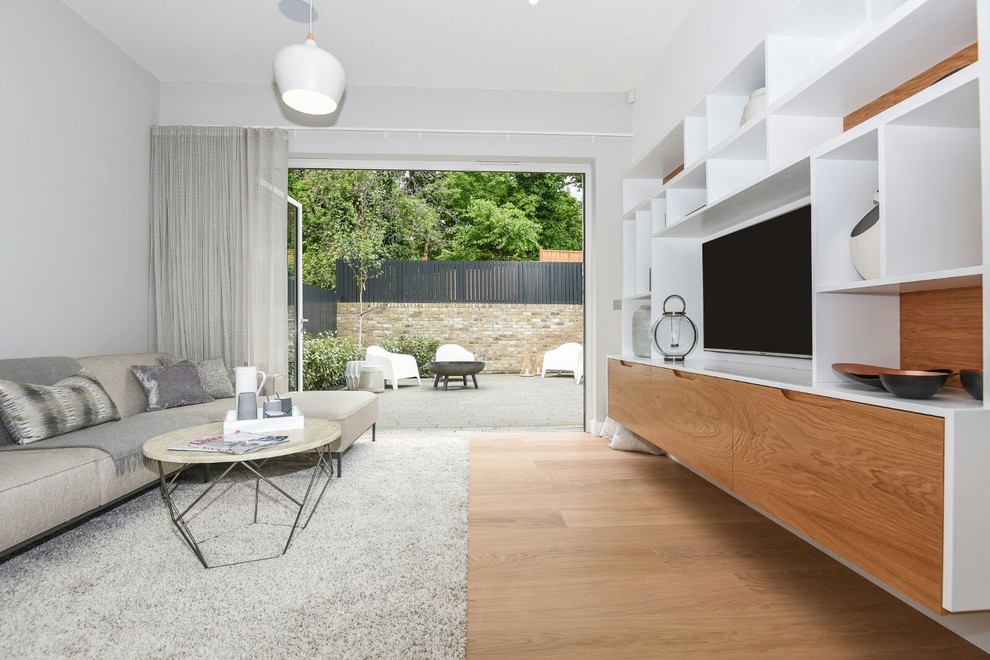 Photo of a contemporary open plan living room in London with grey walls and a wall mounted tv.