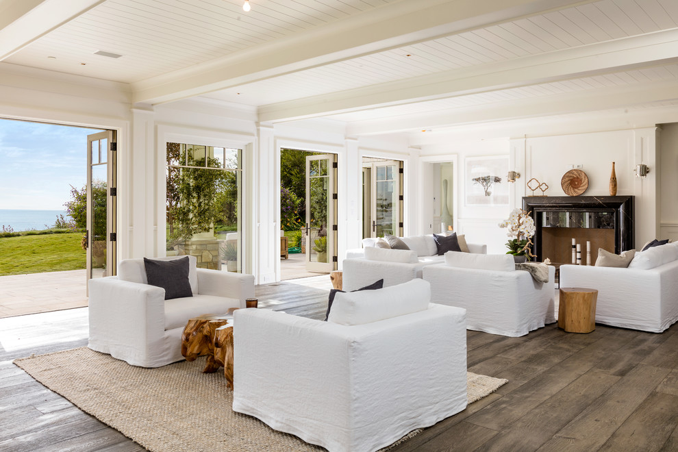 Maritimes Wohnzimmer mit weißer Wandfarbe, dunklem Holzboden, Kamin und braunem Boden in Los Angeles