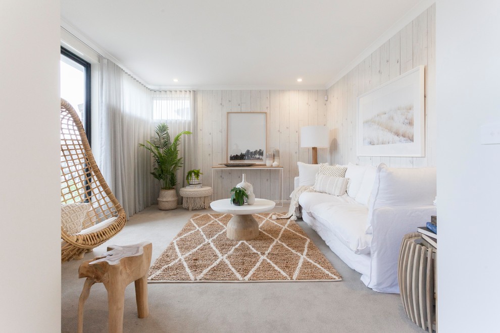 На фото: гостиная комната в морском стиле с белыми стенами, ковровым покрытием и серым полом с