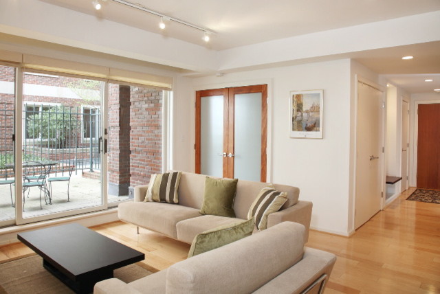 Immagine di un soggiorno design con pareti bianche, parquet chiaro e pavimento marrone