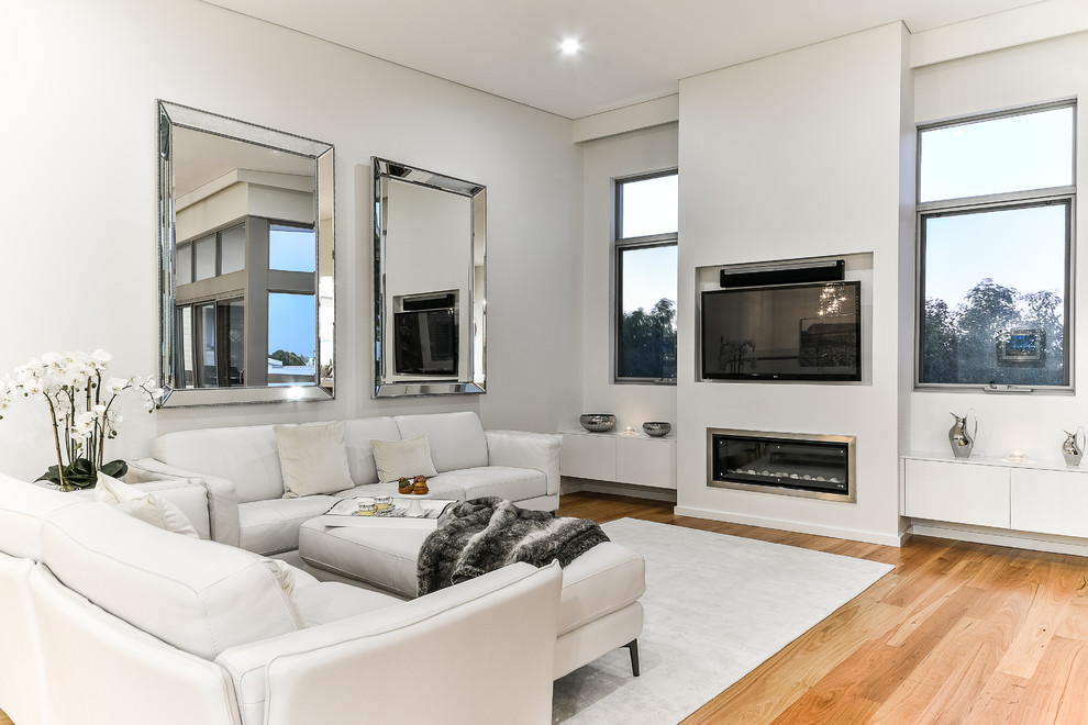 This is an example of a large contemporary open plan living room in Perth with yellow walls, medium hardwood flooring, a ribbon fireplace, a brick fireplace surround and a wall mounted tv.