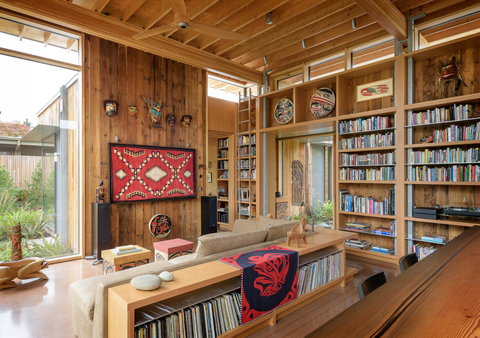 Foto de biblioteca en casa abierta contemporánea de tamaño medio con suelo de cemento, paredes marrones, suelo marrón y madera