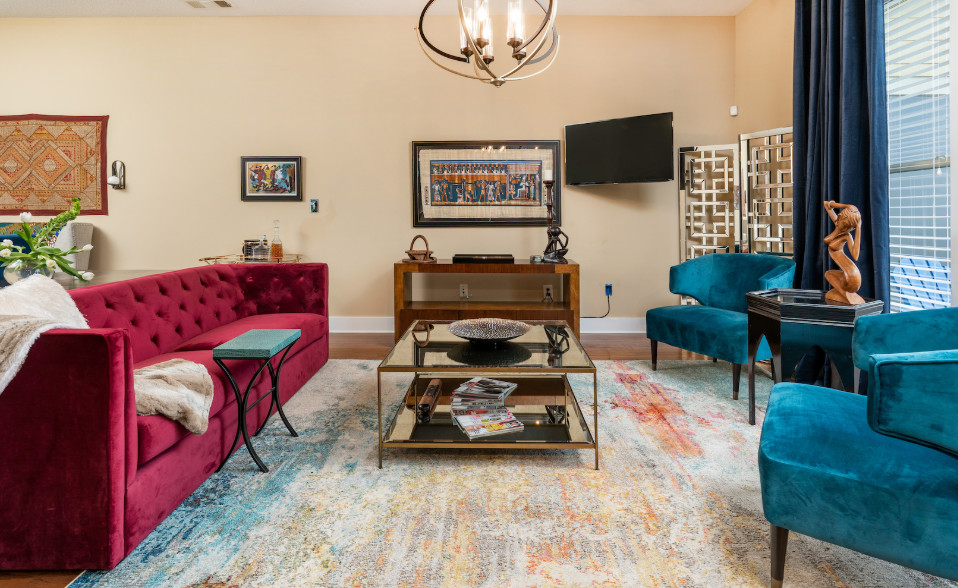Imagen de salón abierto ecléctico de tamaño medio sin chimenea con paredes beige, suelo de madera en tonos medios, televisor colgado en la pared y suelo marrón