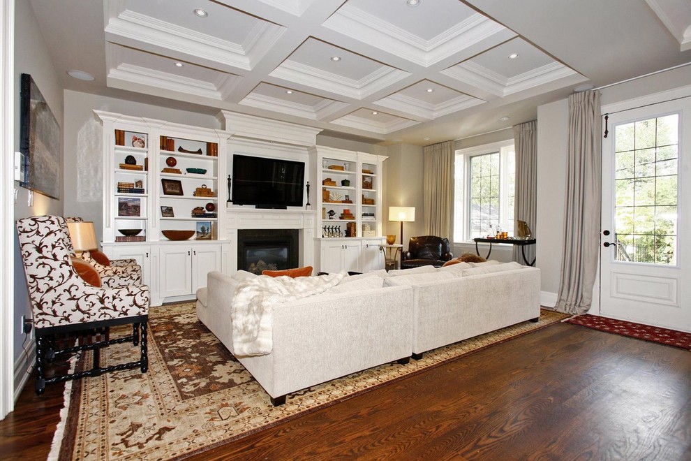 Klassisches Wohnzimmer mit beiger Wandfarbe, dunklem Holzboden, Kamin und Multimediawand in Toronto
