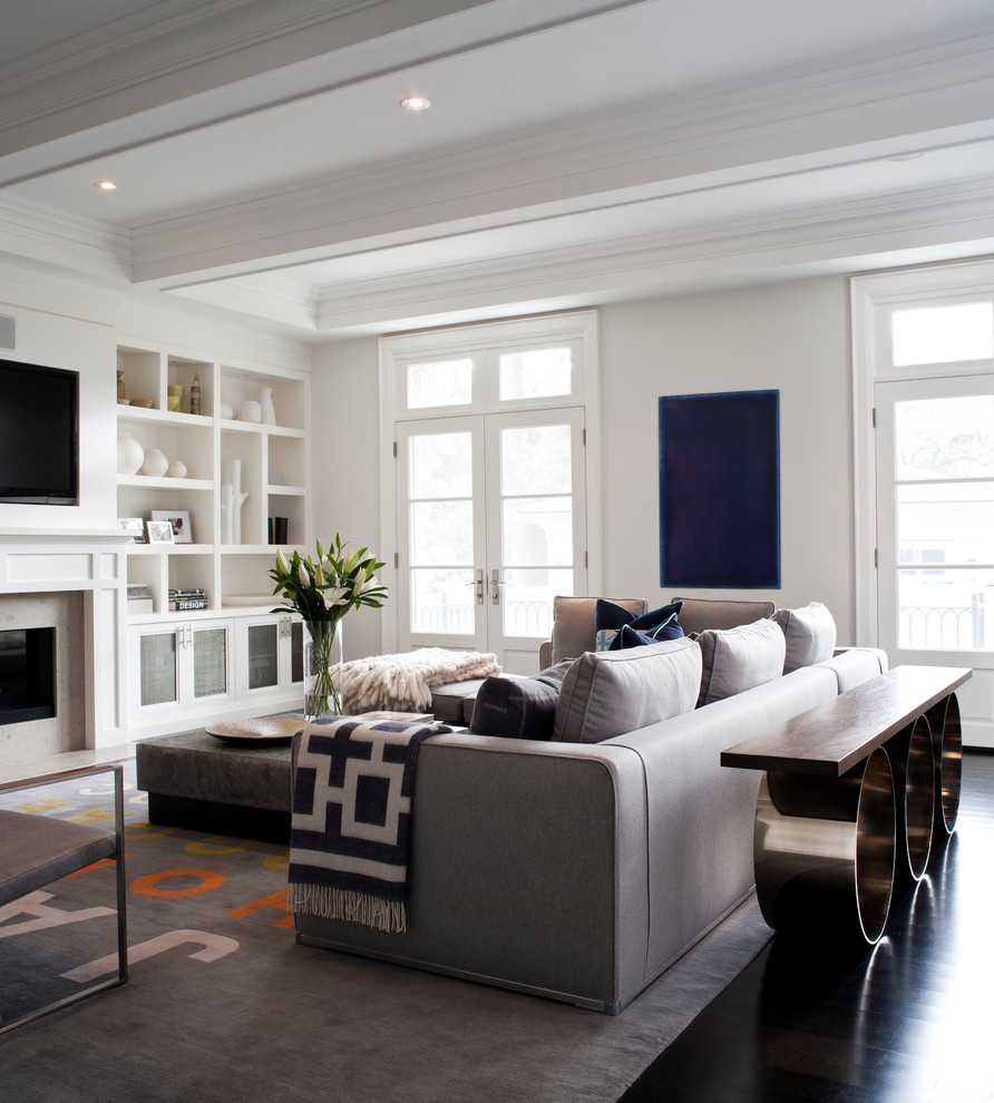На фото: гостиная комната в стиле неоклассика (современная классика) с белыми стенами, мультимедийным центром и ковром на полу с