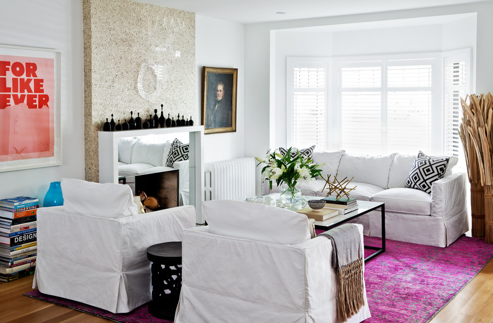 Cette photo montre un salon tendance avec un mur blanc et une cheminée standard.