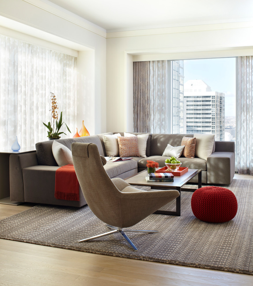 This is an example of a medium sized contemporary open plan living room in Chicago with white walls and carpet.