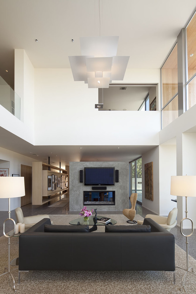 Large trendy open concept concrete floor living room photo in Austin with a wall-mounted tv, white walls, a two-sided fireplace and a concrete fireplace