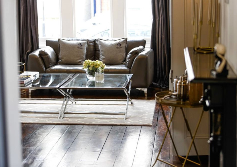 Large traditional open plan living room in London with grey walls and dark hardwood flooring.
