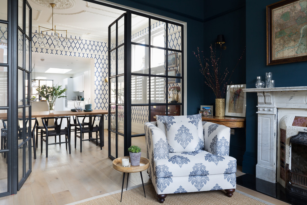 Abgetrenntes Klassisches Wohnzimmer mit blauer Wandfarbe, hellem Holzboden und Kamin in London