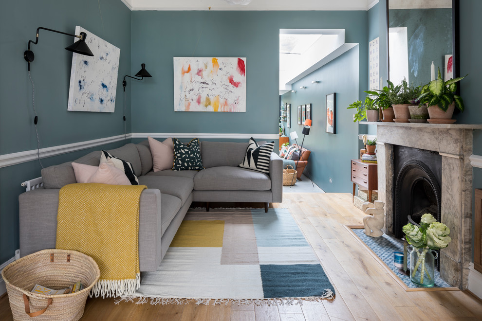 Ejemplo de salón abierto ecléctico de tamaño medio con paredes azules, suelo de madera clara y suelo beige