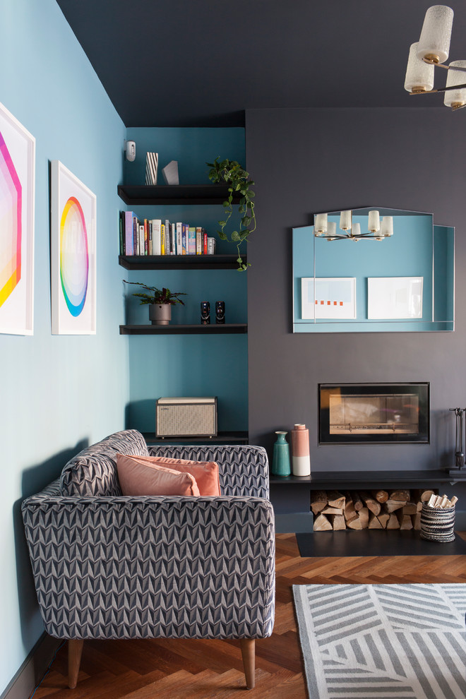 Mittelgroßes, Abgetrenntes Modernes Wohnzimmer mit blauer Wandfarbe, braunem Holzboden und Kaminofen in London