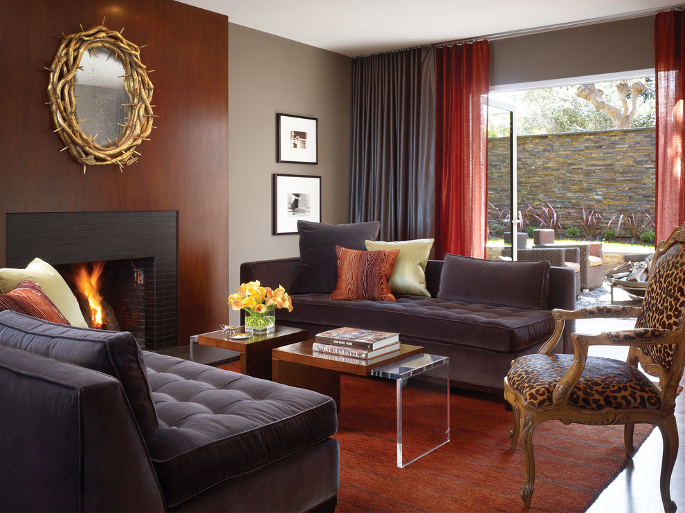 На фото: изолированная гостиная комната среднего размера в стиле фьюжн с коричневыми стенами, темным паркетным полом, стандартным камином и фасадом камина из плитки