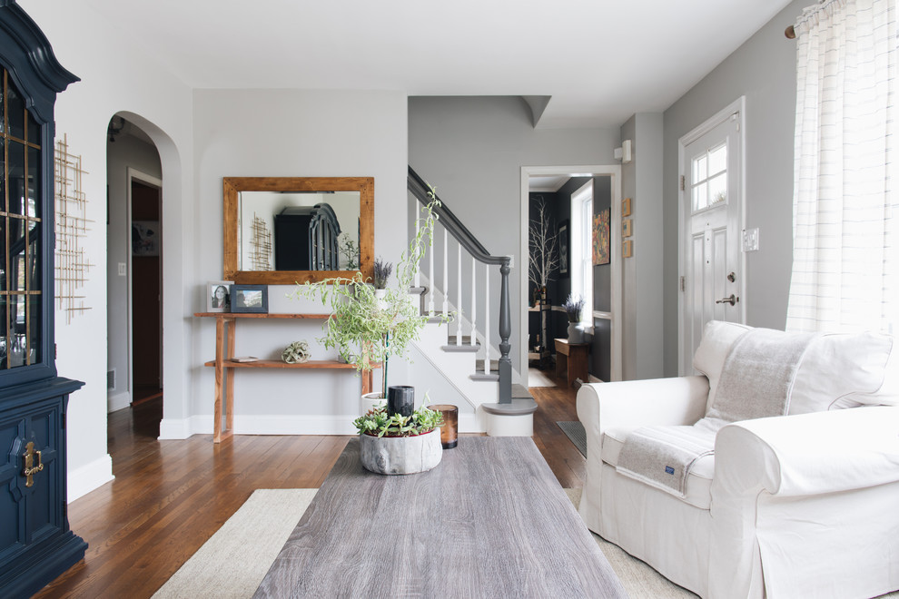 Example of a farmhouse medium tone wood floor and brown floor living room design in Chicago with gray walls