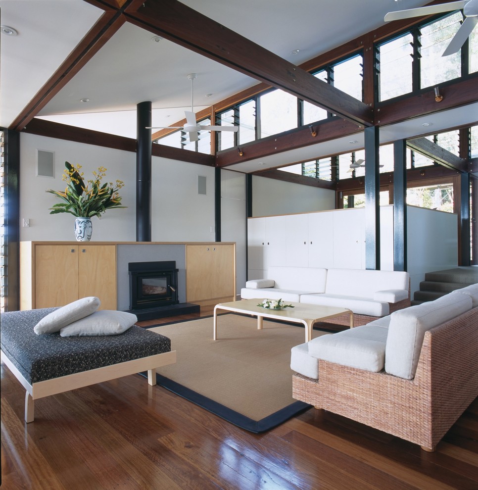 Inspiration for a coastal enclosed and formal medium tone wood floor living room remodel in Sydney with white walls, a ribbon fireplace and a wood fireplace surround