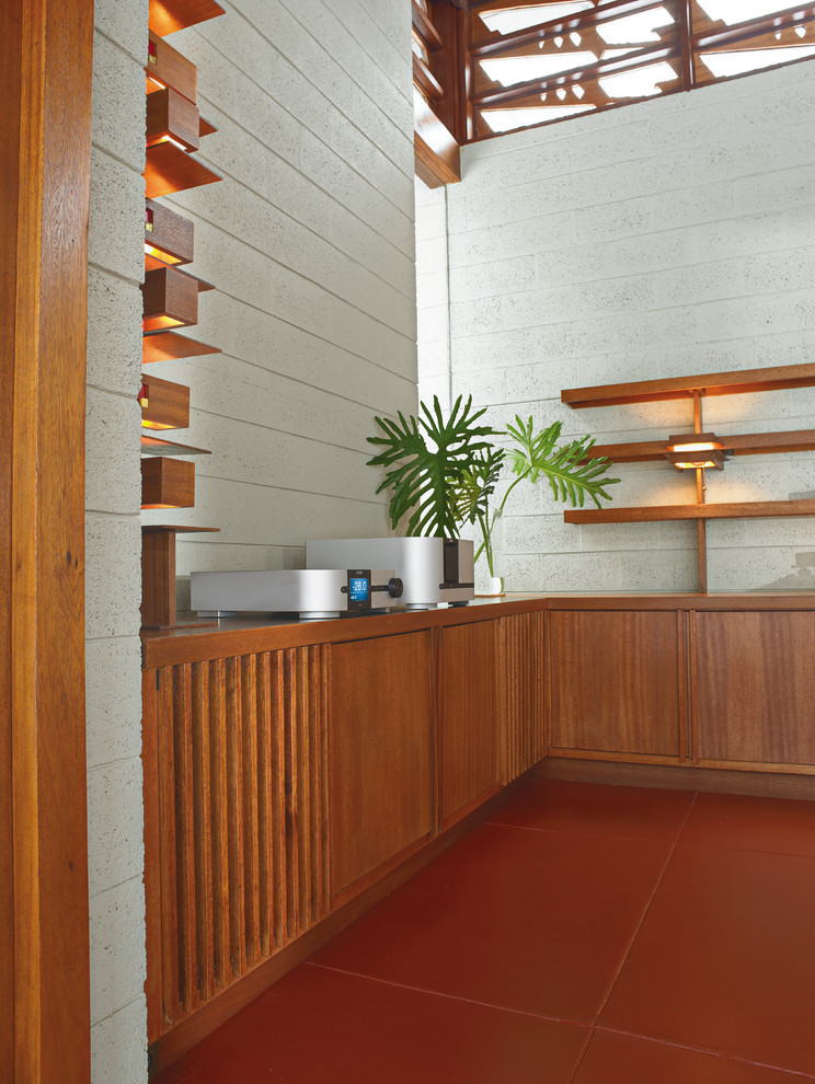 Стильный дизайн: большая открытая гостиная комната в стиле модернизм с бетонным полом, телевизором на стене, серыми стенами, стандартным камином, фасадом камина из бетона и красным полом - последний тренд