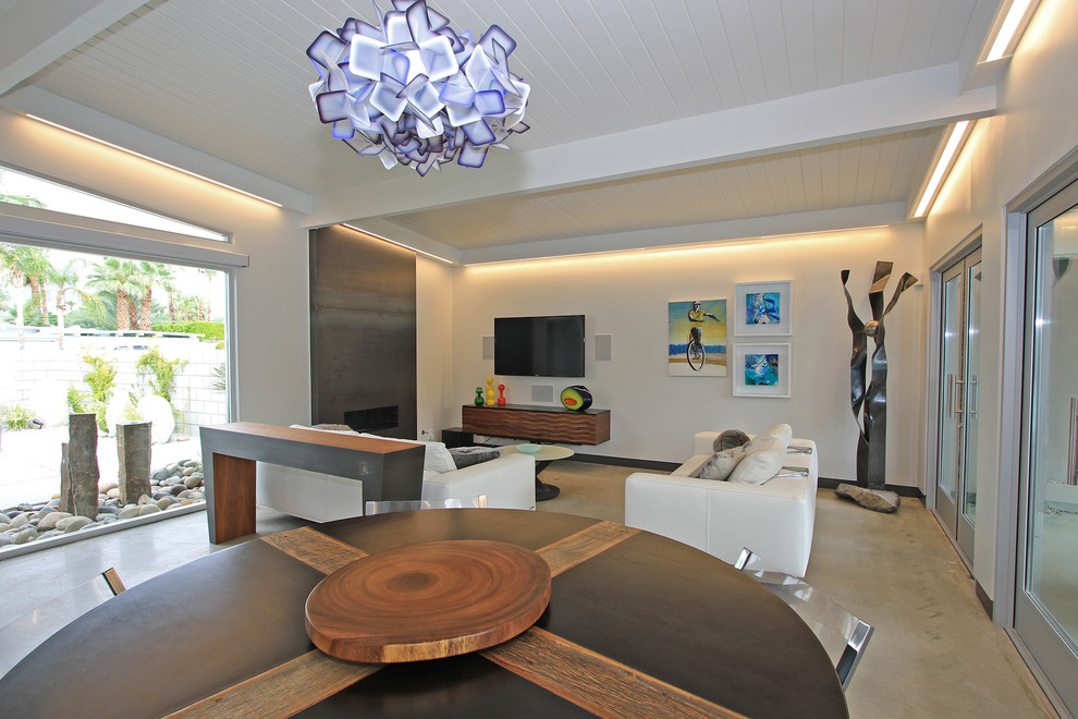 Пример оригинального дизайна: открытая гостиная комната среднего размера в стиле ретро с белыми стенами, бетонным полом, фасадом камина из металла, горизонтальным камином, телевизором на стене и серым полом