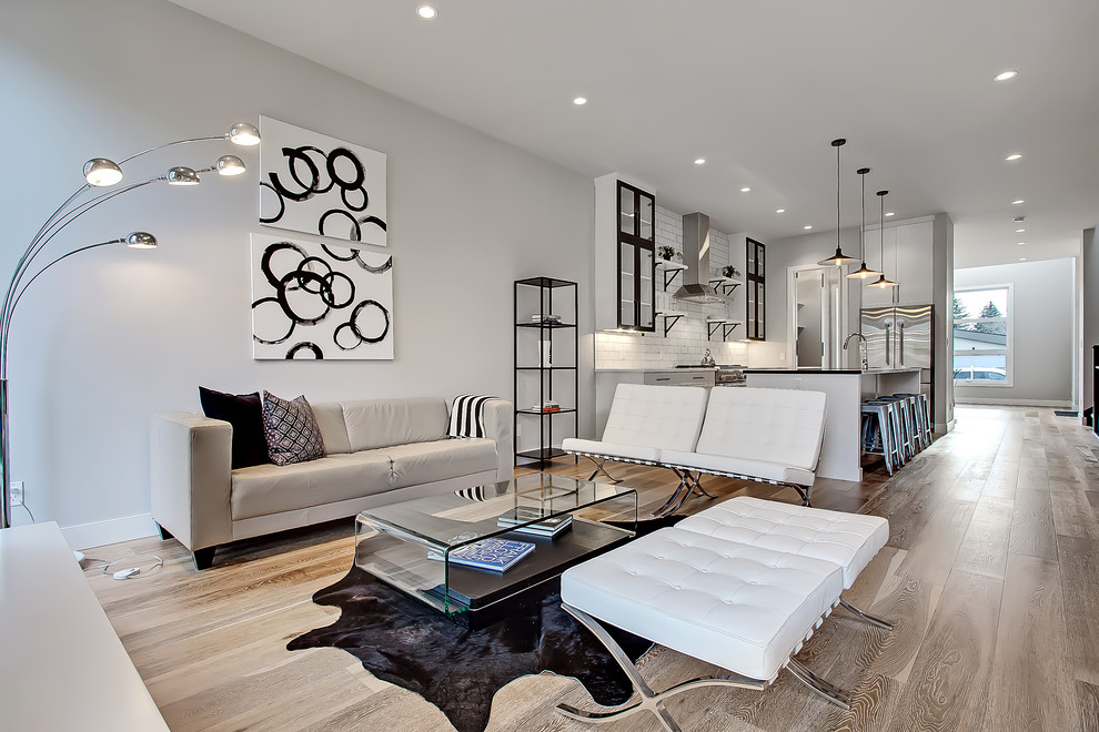 Classic open plan living room in Calgary with grey walls and light hardwood flooring.