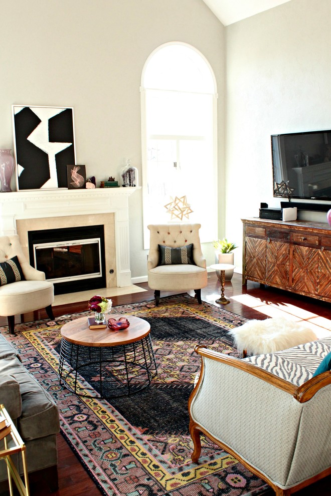 Свежая идея для дизайна: открытая гостиная комната среднего размера в стиле фьюжн с серыми стенами, паркетным полом среднего тона, стандартным камином, фасадом камина из дерева, телевизором на стене и коричневым полом - отличное фото интерьера