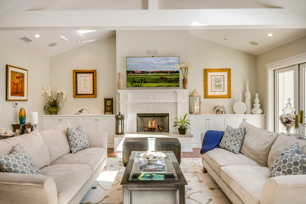 Aménagement d'un salon classique de taille moyenne et ouvert avec un mur beige, un sol en bois brun, une cheminée standard, un manteau de cheminée en carrelage et une salle de réception.