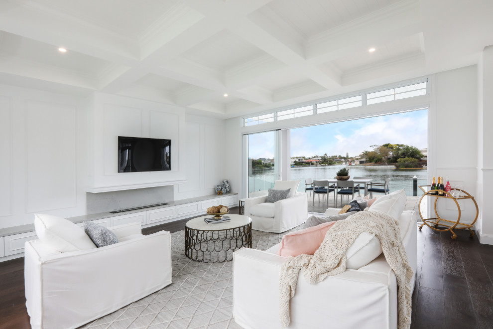 Offenes Maritimes Wohnzimmer mit weißer Wandfarbe, dunklem Holzboden, Gaskamin, TV-Wand und braunem Boden in Gold Coast - Tweed