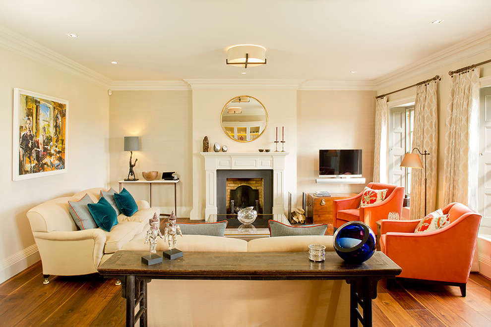 Inspiration pour un salon traditionnel de taille moyenne avec un mur beige, une cheminée standard, un manteau de cheminée en brique, un téléviseur indépendant et un sol en bois brun.