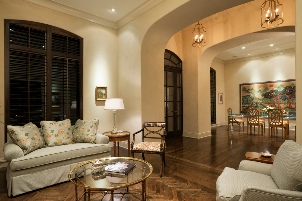 Immagine di un grande soggiorno classico aperto con parquet scuro, pareti beige, camino classico, cornice del camino in pietra e sala formale