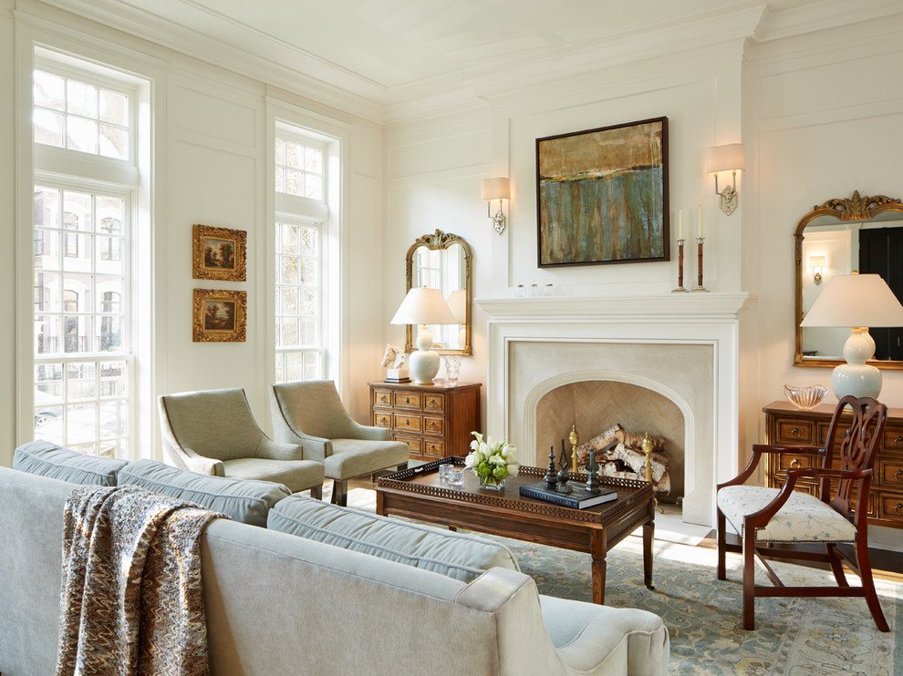 На фото: большая парадная, изолированная гостиная комната в классическом стиле с белыми стенами и стандартным камином