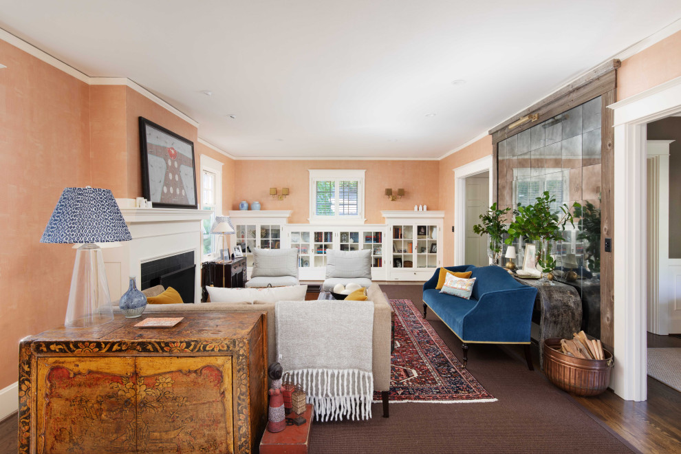 На фото: изолированная гостиная комната среднего размера в стиле неоклассика (современная классика) с оранжевыми стенами, темным паркетным полом, коричневым полом и синим диваном с