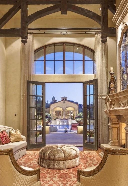 Inspiration for a large mediterranean open plan living room in Phoenix with beige walls, travertine flooring, a corner fireplace, a stone fireplace surround and a built-in media unit.
