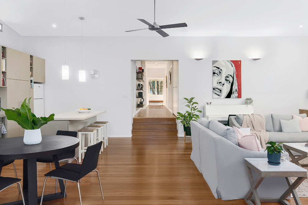 Foto di un soggiorno minimal di medie dimensioni e aperto con pareti grigie, pavimento in legno massello medio e parete attrezzata