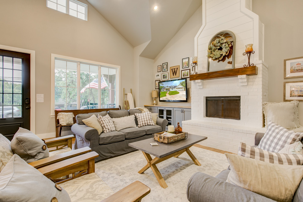 Design ideas for a country open plan living room in Dallas with a standard fireplace, a brick fireplace surround and a vaulted ceiling.