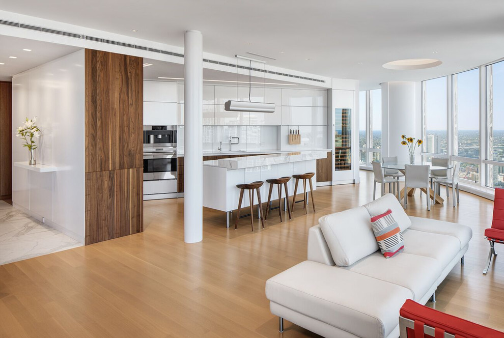 Immagine di un grande soggiorno contemporaneo aperto con pareti bianche, pavimento in legno massello medio e pavimento beige