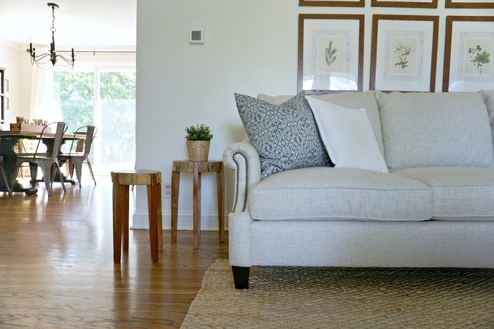 Immagine di un soggiorno minimalista di medie dimensioni e aperto con pareti bianche, pavimento in legno massello medio e pavimento marrone