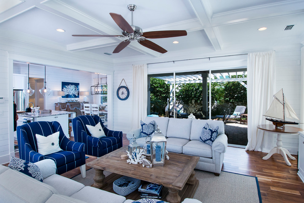 Inspiration for a large coastal open plan living room in Jacksonville with white walls, dark hardwood flooring, no fireplace, a built-in media unit and brown floors.