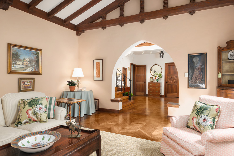 На фото: большая парадная, изолированная гостиная комната в средиземноморском стиле с розовыми стенами, паркетным полом среднего тона, стандартным камином, фасадом камина из дерева и коричневым полом с