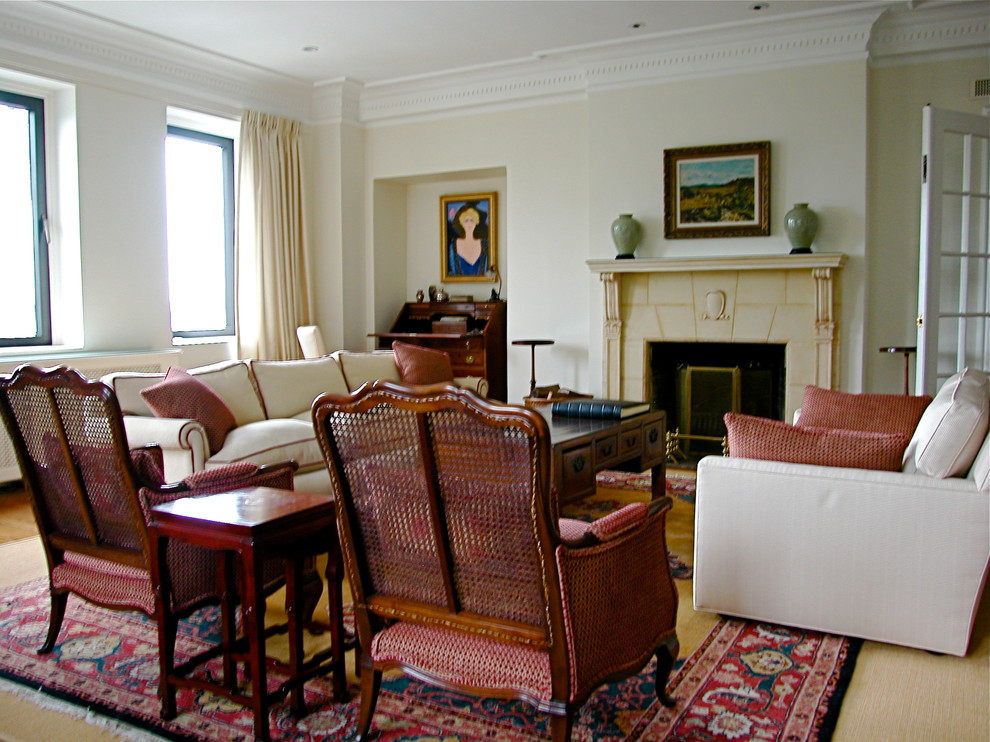 Пример оригинального дизайна: большая открытая гостиная комната в классическом стиле с с книжными шкафами и полками, бежевыми стенами, паркетным полом среднего тона, стандартным камином, фасадом камина из плитки и телевизором на стене