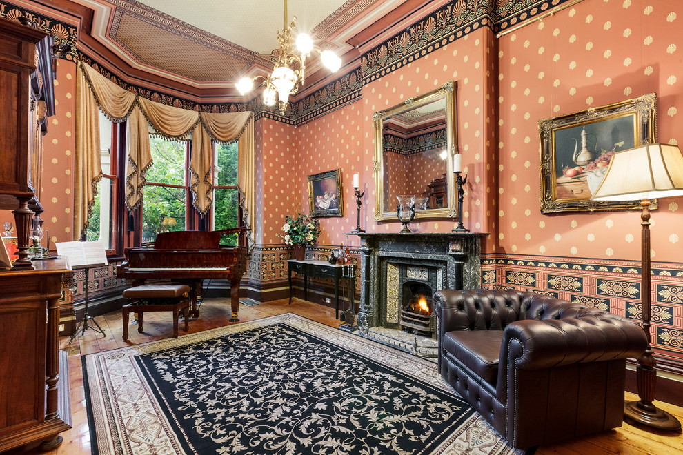 На фото: изолированная гостиная комната в викторианском стиле с музыкальной комнатой, красными стенами, темным паркетным полом, стандартным камином, фасадом камина из камня и коричневым полом с