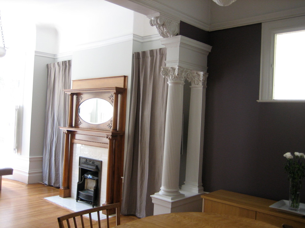 На фото: маленькая парадная, открытая гостиная комната в викторианском стиле с фиолетовыми стенами, светлым паркетным полом, стандартным камином, фасадом камина из дерева и скрытым телевизором для на участке и в саду с