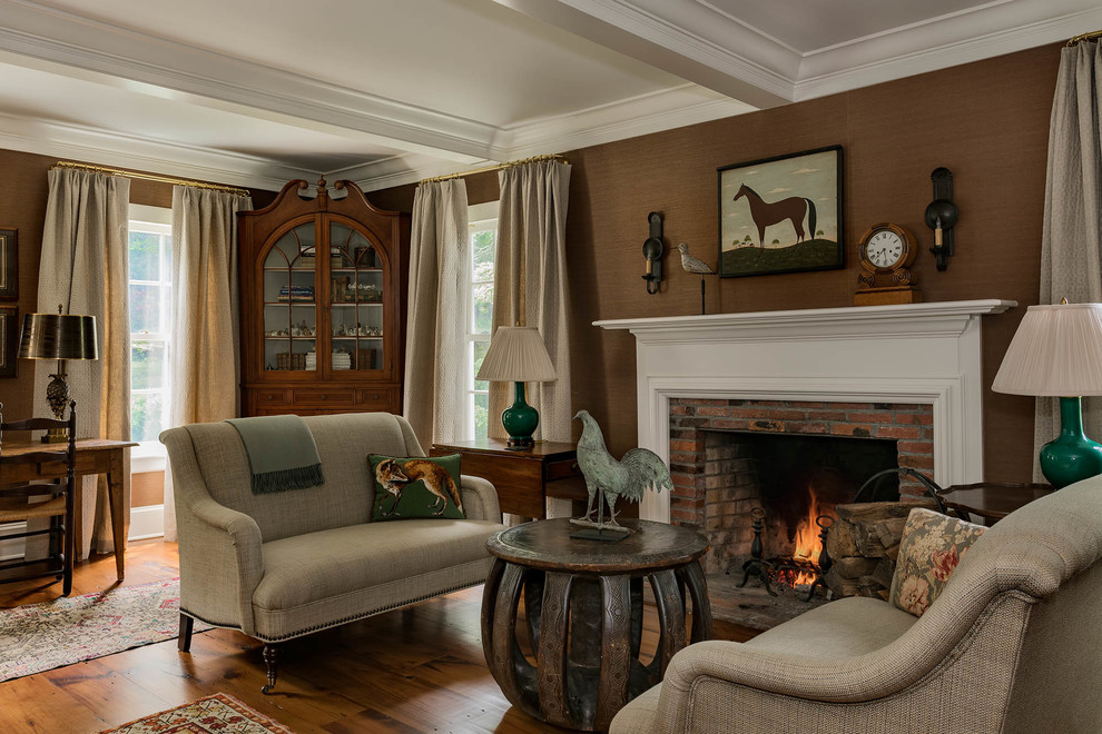 Cette image montre un salon rustique avec une salle de réception, un mur marron, parquet foncé, une cheminée standard, un manteau de cheminée en brique et un sol marron.